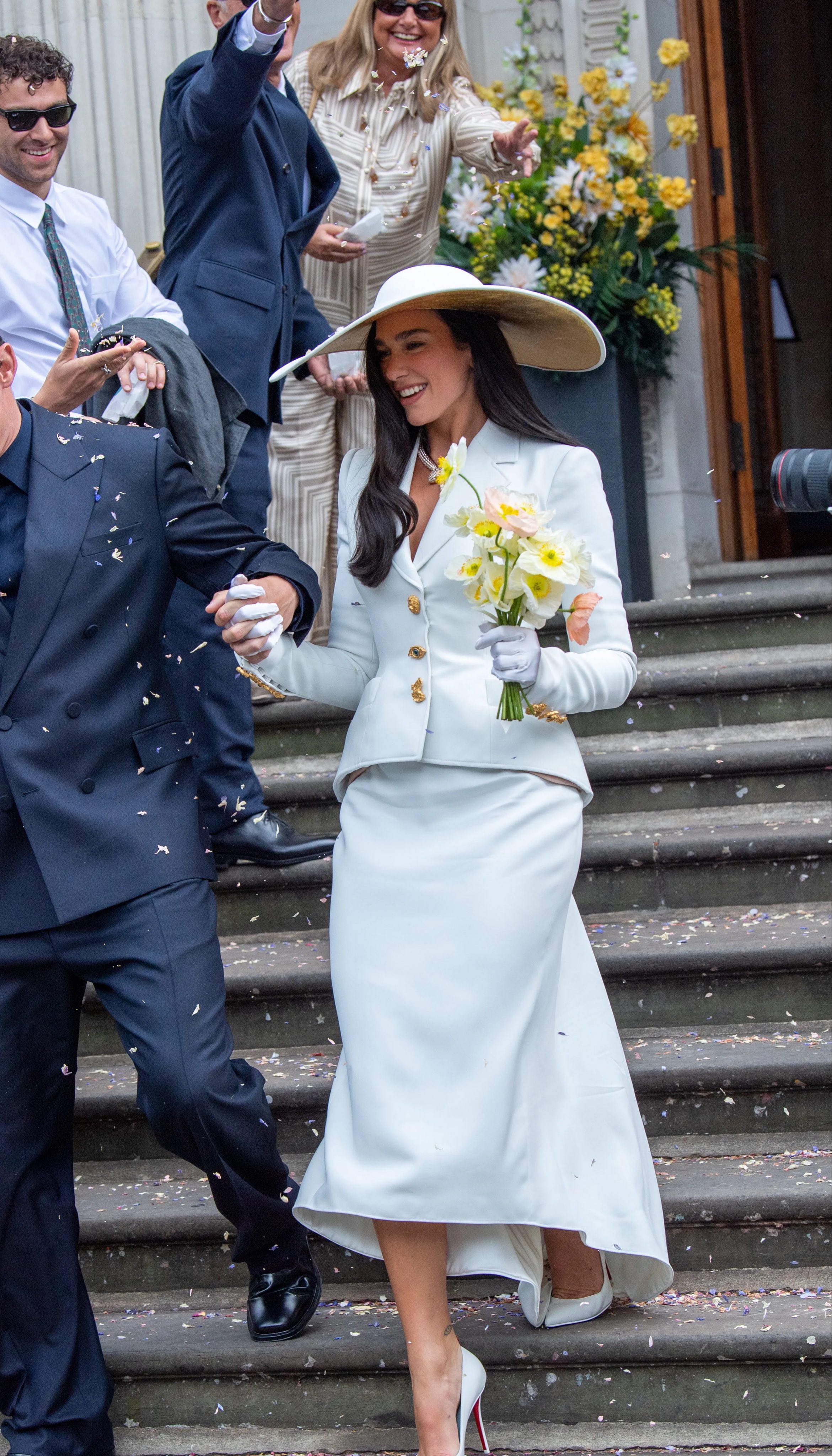 Dua Lipa carries a bouquet of yellow daffodils on her wedding day